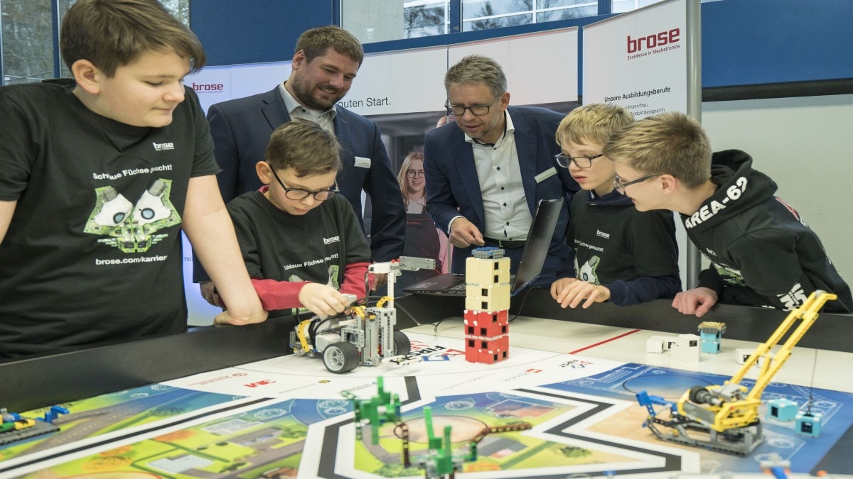  Debut for the JEG-Robots in the First Lego League in Würzburg. Mark, Benjamin, Alexander and Lukas (from left) explain how their robot works to Michael Stammberger (third from right) and Stefan Pausch from Apprenticeship Brose Group. 