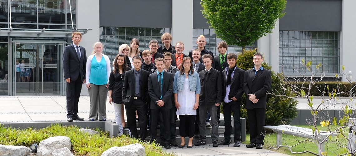 Michael Stammberger, head of apprenticeship training (left), and the Brose apprentices from Coburg and Hallstadt.